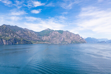Obraz premium Lake Garda with mountain landscape and coastal town. Wide water surface and alpine scenery in northern Italy travel destination