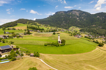 Church of Saint Valentine set by meadows on Seiser Alm, Dolomites, aerial view. Rural religious site on an alpine plateau © Leonid