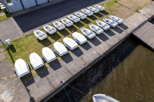 Aerial wide angle view of white sailing dinghies parked in rows at a marina