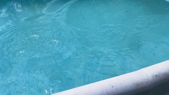 Horizontal Close up of the hands cleaning a swimming pool with a special pool cleaning net. side view