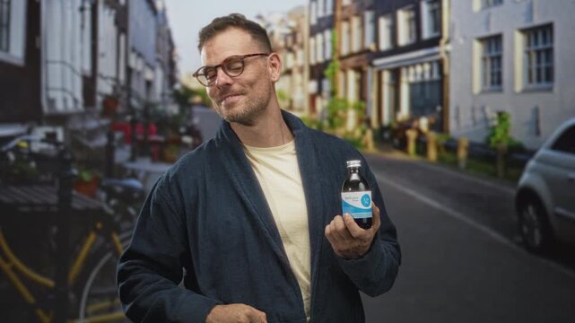 Man in robe holds cough syrup bottle, thumb pointing to chest on a residential street; health relief.