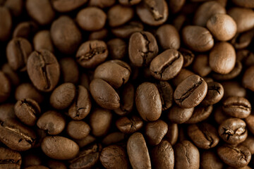 Obraz premium Close-up of roasted coffee beans on white background, rich aroma and texture, perfect for espresso concept, café menu, and energetic morning beverage theme. 
