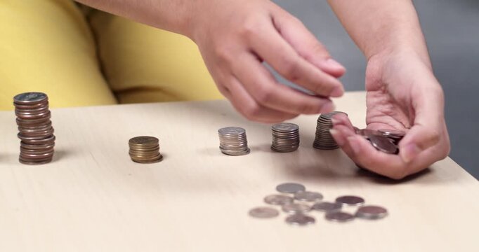 A detailed look at hands skillfully stacking coins in a home setting.