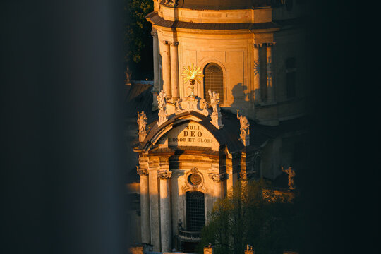 Venetian cathedral facade with Latin inscription Soli Deo Honor et glory bathed in golden hour sunlight