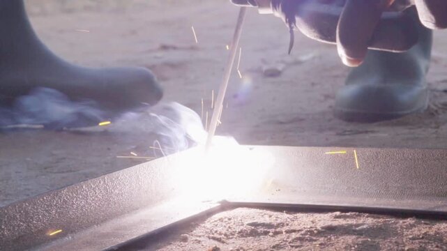 Welder working on a metal frame at a farming center in Tanzania