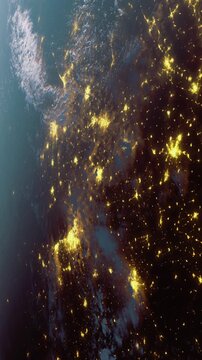Glowing lights from bustling cities illuminate the landscape as seen from space. The scene captures a beautiful contrast of dark land and shining urban areas at night.