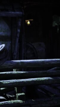 Amidst a dimly lit space, weathered wooden beams and shadows create a mysterious atmosphere. A round object rests against the rustic wood, hinting at quiet stories of the past.