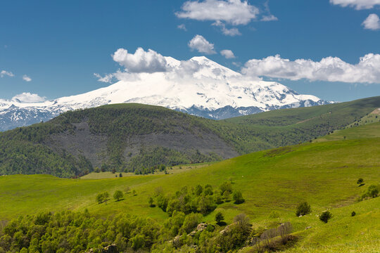 Landscape of snow-capped Elbrus and foothills in Caucasus mountains at summer