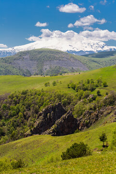 Landscape of snow-capped Elbrus and foothills in Caucasus mountains at summer