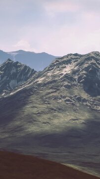 Gentle light caresses rugged mountain peaks, casting deep shadows on the green slopes. The serene scene evokes a sense of peace and connection to natures wild terrain.