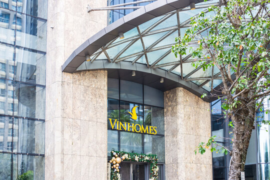The modern glass and stone facade of a residential building with corporate signage. Urban architecture, real estate development, city exterior.Vietnam, Ho Chi Minh City, December 13, 2026
