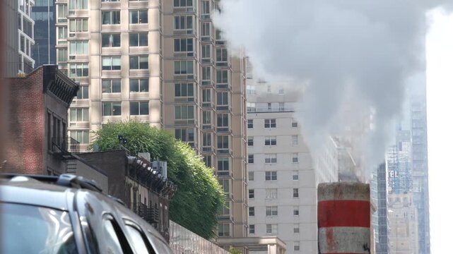 New York City Midtown urban tall buildings architecture, Manhattan straight street, 8th eights avenue, United States of America. Skyscraper towers near Columbus Circle, USA. Hot steam smoke vapor.