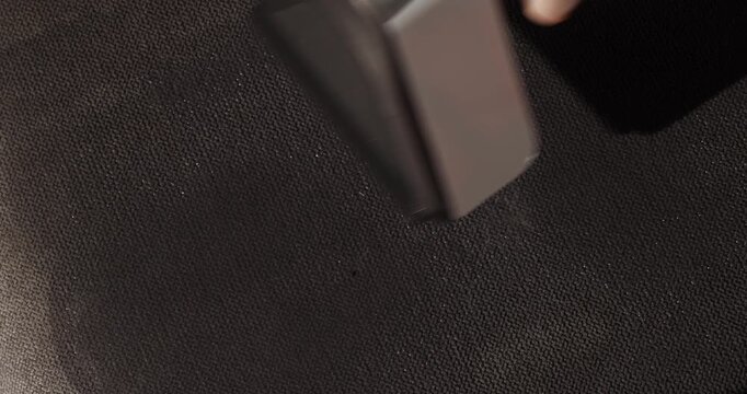 Spray bottle and cloth clean a dark surface during home maintenance