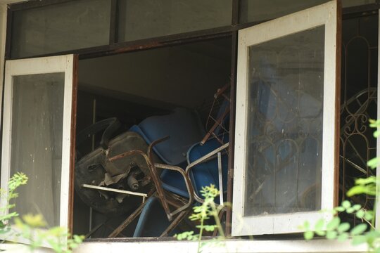 broken blue chair and table arranging block window in old school building on Thailand