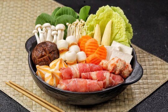 Sukiyaki and shabu-shabu, popular Japanese hot pot dishes featuring thinly sliced beef, fresh vegetables, tofu, mushrooms, noodles, and flavorful broth.