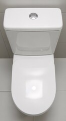 Fototapeta premium Modern white toilet in bathroom overhead view on gray tiles background