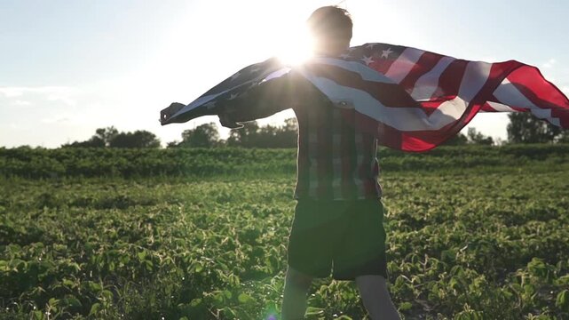 little boy - American patriot kid running with national flag on open area field.