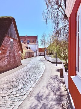Empty cobbled street through Nordby village on a sunny spring day, Fanoe, Jutland, Denmark