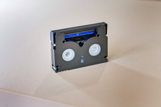 Small Retro MiniDV Video Cassette on a Beige Surface
