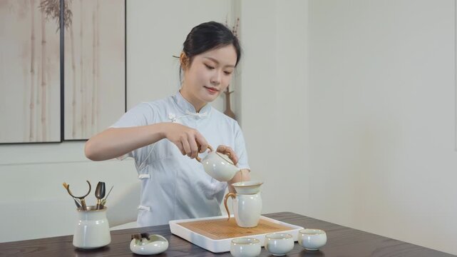 Professional hands of tea master young woman prepare traditional ritual culture ceremony teapot with tea brew technique over table serving guests drink teacup classic teahouse for cultural experience