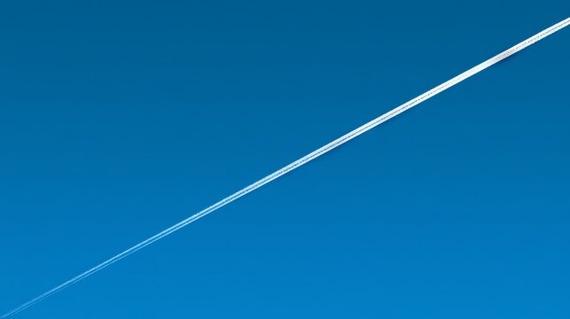 Blue sky contrail minimalism travel calm background clean composition with diagonal line across clear sky, serene atmosphere concept for design projects and peaceful open space visuals