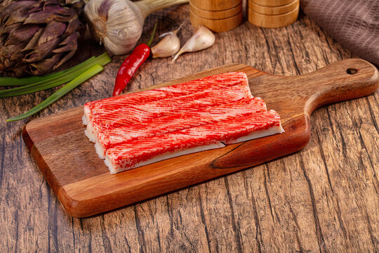 Imitation Crab Sticks on Wooden Cutting Board with Fresh Vegetables