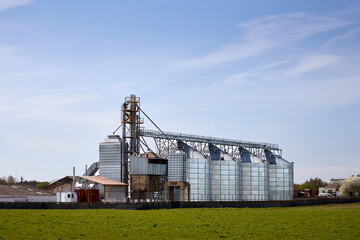 Granary elevator silver silos and machinery for handling grain on agro-processing and manufacturing plant for processing drying cleaning and storage of agricultural products, flour, cereals and grain. © R_Yosha