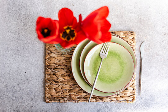 Overhead view of a rustic Spring place setting on a table with red tulips