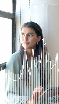 Vertical video: Woman tapping tablet by window, turning gaze out reflecting, tech waveform reacting