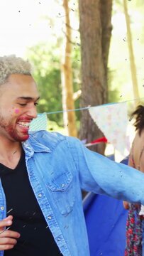 Vertical video: Campers celebrating after laugh she smiling he dancing by blue tent floating specks