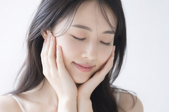 頬に手を添えて目を閉じ微笑む美しい日本人女性のビューティーポートレート Generative AI