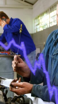Vertical video: Mechanic wiping rod, placing and tuning it in engine to align, purple wave overlay