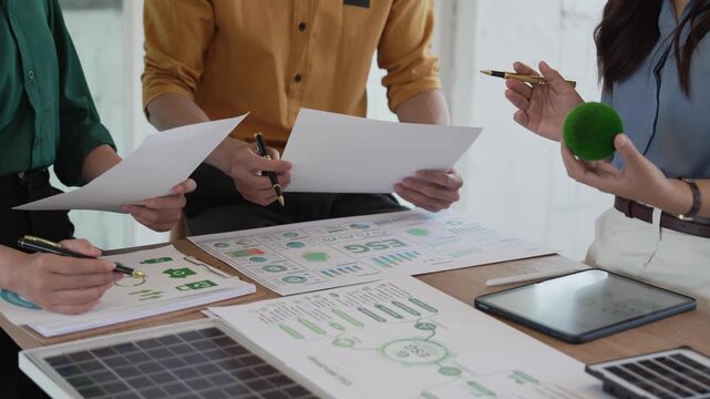 Business professionals are meeting to plan strategies, analyze ESG performance indicators, and develop sustainability strategies incorporating clean energy concepts.