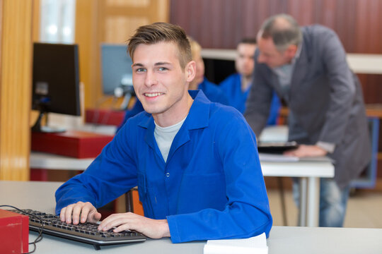 portrait of male teenager in blue jacket using computer