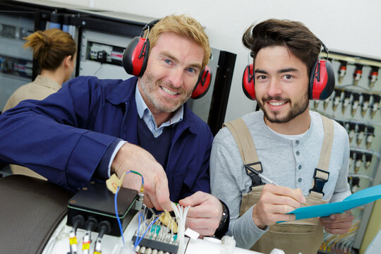2 electronic engineers looking at the camera