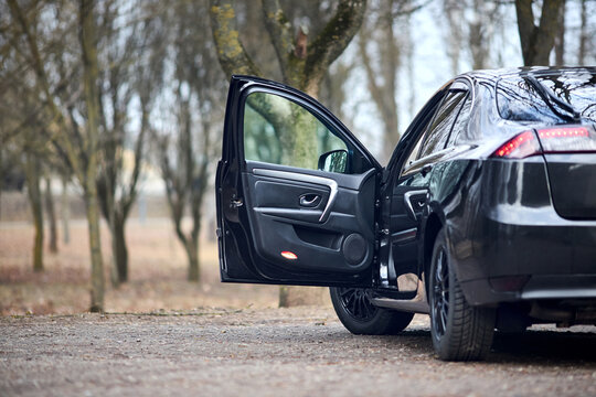 car parked on street in spring back rear three quarter view with opened door.