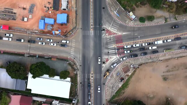 High-quality 4K aerial nadir view of a city intersection and roadwork site, featuring vehicle flow and infrastructure development, highlighting urban transit logistics.