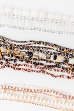 A pile of gemstones and pearls beads for jewelry, top view, flat lay