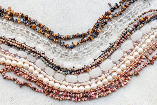Necklaces of many gemstones beads and pearls, top view. Jewelry concept.