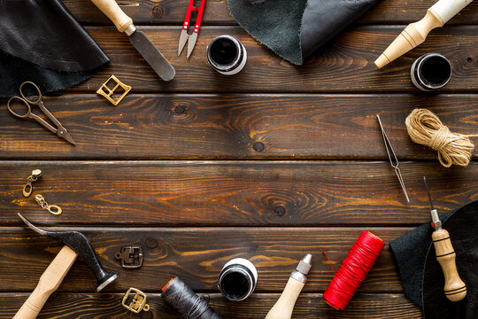Frame flat lay of leather craftsman or shoemaker tools and equipment, top view