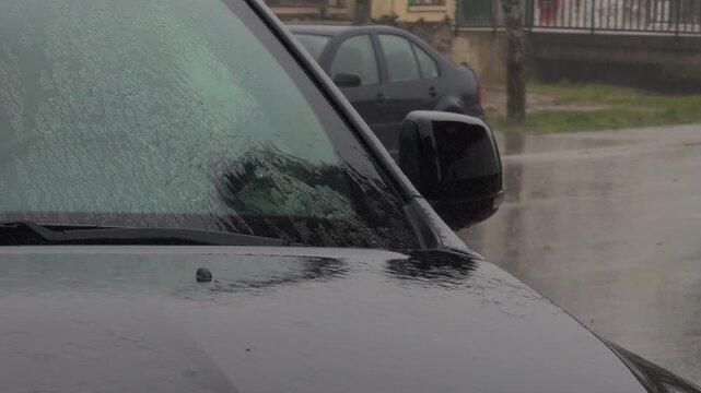 Dark Car Parked Under Heavy Rain and Gray Skies