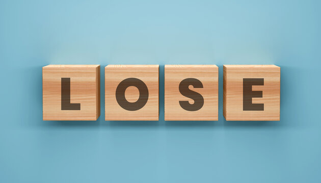 The Concept of Loss: Wooden blocks spell out the word LOSE, set against a clean backdrop, creating a stark visual reminder of setbacks.