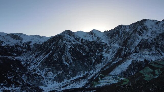 Majestic Snowy Mountain Range Under Twilight Sky with Glacial Trails