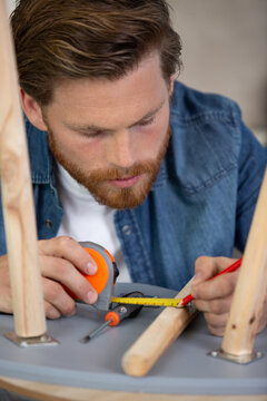 furniture production maker in workshop making wooden chair