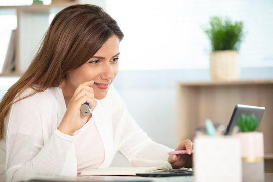 beautiful brunette smoke electronic cigarette and working on her laptop