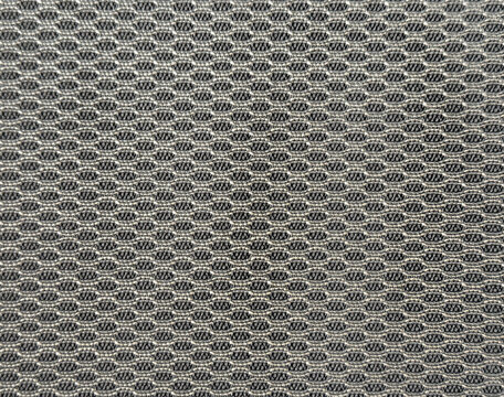 Close up of knitted wear fabric in grey color. Knitted sweater fabric forming net or lattice shape. Seamless background texture.