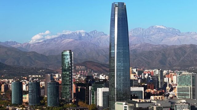 Glass Skyscraper Tower Reflecting Sunlight over Santiago Downtown with Andes Mountains, Chile, South America