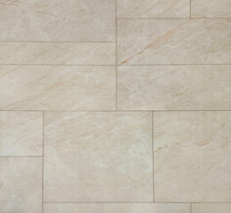 Close up of beige marble tiles with random rectangular tiling arrangement with black grouts. Suitable for wall tiles and floor finishes. Seamless background texture