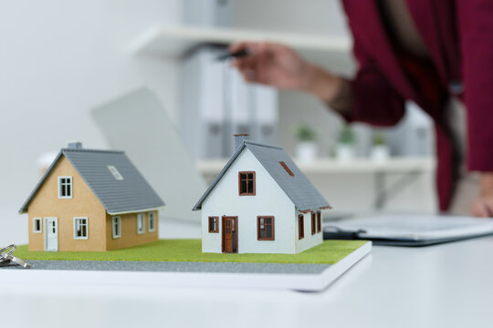 Close-up of Miniature House Models and Keys on Desk