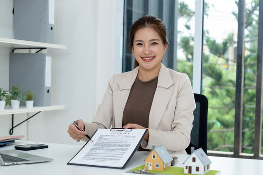 Female Real Estate Agent Presenting Contract Document at Office Desk